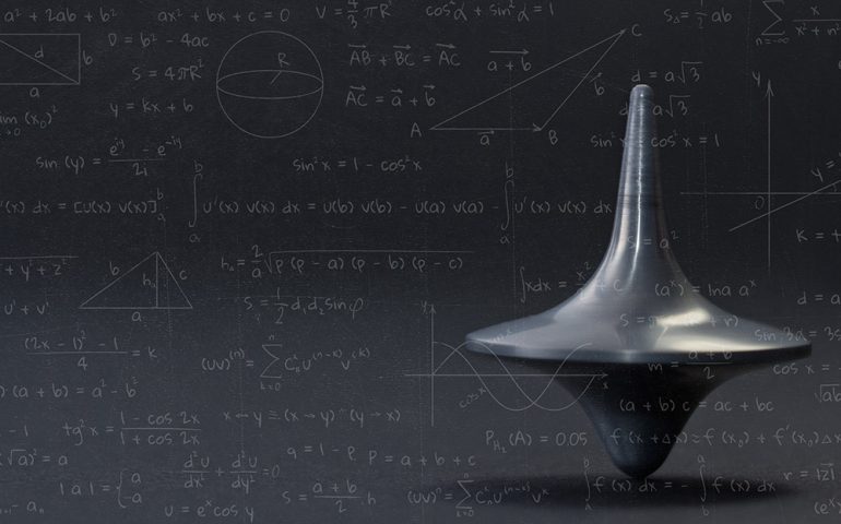 Mathematics and Quantum Science. Spinning top with maths equations on top.